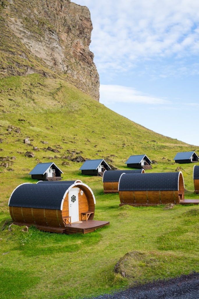 Cozy wooden cabins nestled amidst rolling green hills, perfect for a tranquil rural getaway.